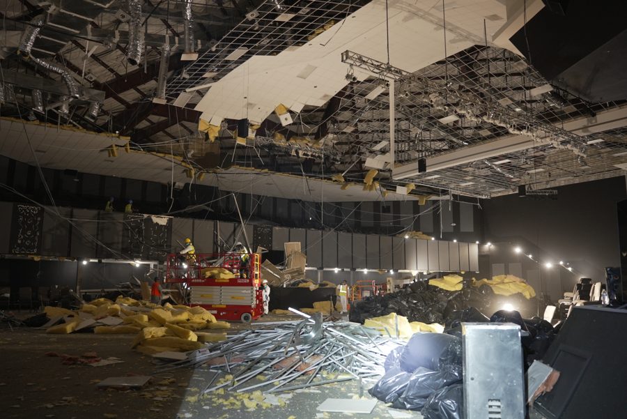 Debris and insulation piled across the sanctuary floor beneath the collapsed ceiling
